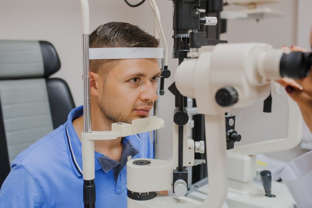 young patient in clinic doing biomicroscopy with slit lamp procedure