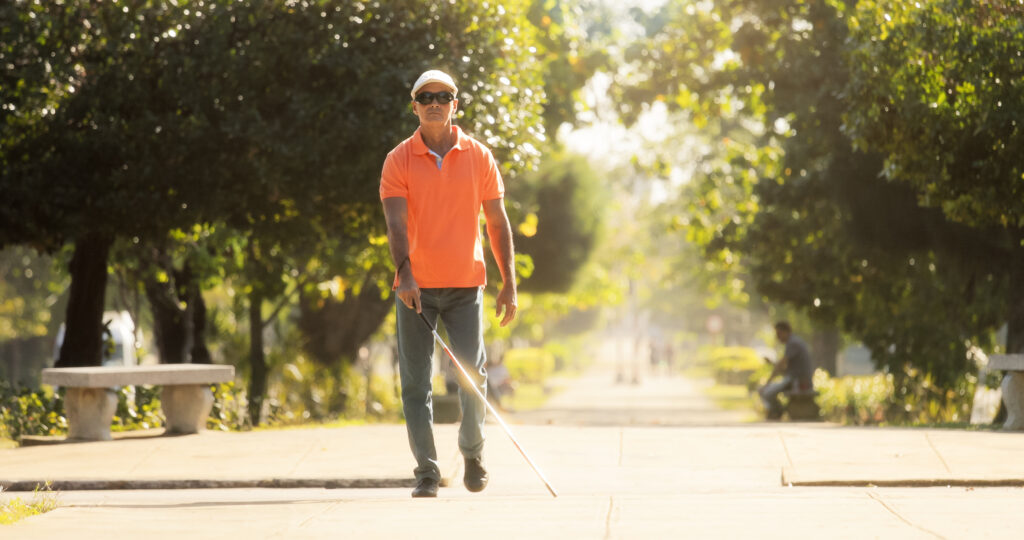 Blind Man Crossing The Street And Walking With Cane