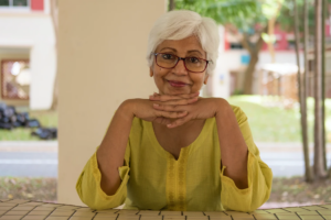 smiling old woman sitting front of table